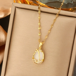 Detail of golden necklace with a white tulip pendant and sparkling pavé crystals