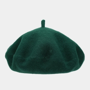 Detail of a thick wool beret in dark green with a top stem and high-quality felt texture