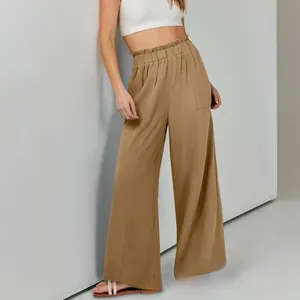 Dettaglio dei pantaloni larghi in lino kaki a vita alta elastica con volant e tasche laterali