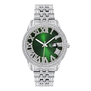 Detailed close-up of a luxury men's silver watch with green dial and iced-out crystals