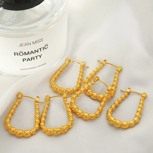 Minimalist geometric gold drop earrings featuring a beaded triangle and round design