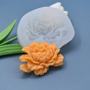 Macro detail of silicone peony mold showing intricate petal texture with finished orange flower