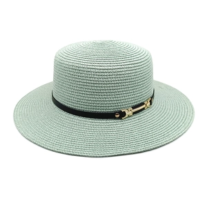 Détail du chapeau de paille vert menthe avec bande en cuir noir et boucle dorée en métal