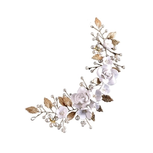 Detailed bridal hair vine with white ceramic flowers, gold leaves and pearls on white