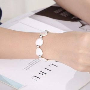 Bracelet élégant en perles d'acier argenté avec pendentif cœur en nacre pour femme