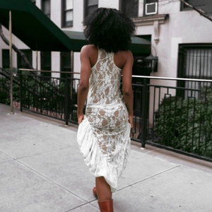 Photo de rue d'une femme portant une robe en dentelle blanche sans manches à volants