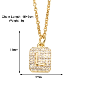 Detail of gold rectangular pendant with pavé cubic zirconia and letter L engraving