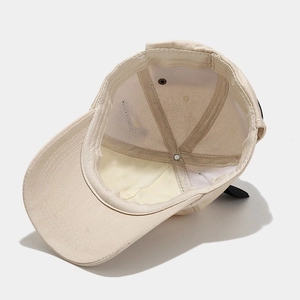 Detailed interior of beige cotton baseball cap showing sweatband and reinforced stitching
