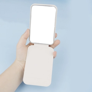 Close-up of portable folding makeup mirror with beige PU leather texture and flip stand