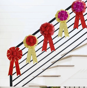 Close-up of glittery rose red and gold Christmas bows on a modern black stair railing