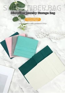 Macro view of microfiber suede jewelry pouches in five colors on marble background