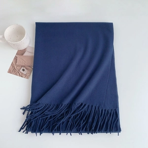 Close-up detail of soft navy blue fringe scarf with high-quality cashmere texture