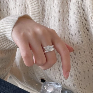 Detail shot of a silver S925 ring with irregular lava texture worn on a finger