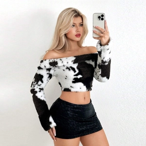 Detail of off-shoulder cropped top in cow print plush faux fur with slim long sleeves