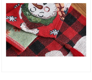 Macro view of Christmas table runner with red black plaid, snowman jacquard and red tassel