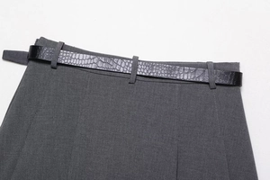 Close-up of a dark grey skirt waist with a black crocodile pattern embossed PU belt