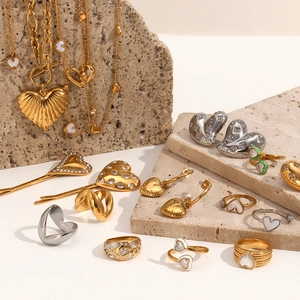 Detail view of heart-shaped jewelry set with 18K gold plating on textured stone base
