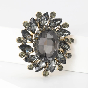 Detailed macro view of a vintage floral brooch with gray multifaceted crystals and bronze metal