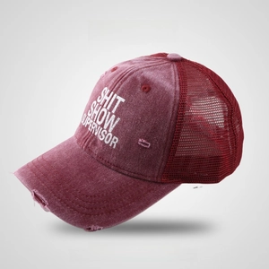 Detail of burgundy vintage baseball cap with mesh back and distressed frayed brim edges