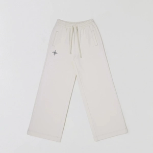 Macro detail of cream cotton wide-leg joggers featuring drawstring waist and petal logo