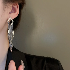 Silver leaf fringe earrings with geometric diamond-shaped tassels on elegant model