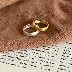 Detailed view of handmade matte texture rings on a vintage book and brown knit fabric