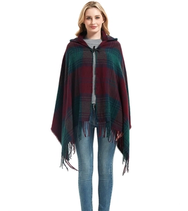 Detail of red and green plaid hooded poncho featuring horn buttons and fringe trim