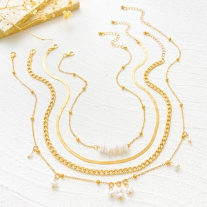 Conjunto de collares dorados de varias capas con perlas blancas y cadenas geométricas