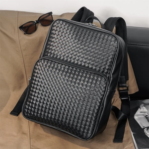 Close-up of black woven leather texture and double zipper detail on professional backpack