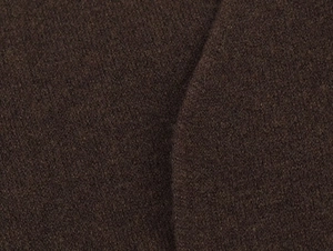 Dettaglio del tessuto a maglia spessa marrone scuro di qualità con texture morbida