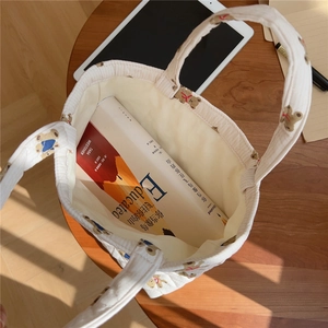 Detailed top view of a quilted bear tote bag interior showing practical book storage space