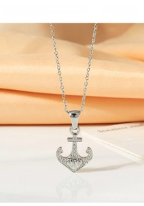Close-up of titanium steel anchor pendant with zircon inlay on a textured card