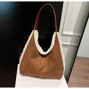 Detailed view of the brown suede handbag with plush white fur trim and handles