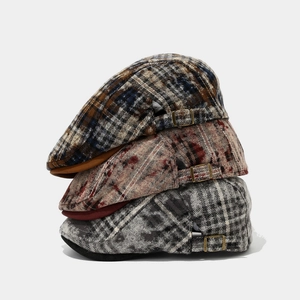 Three vintage plaid newsboy caps in brown, red, and grey with adjustable metal side buckles
