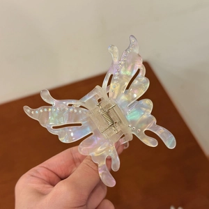 Colorful acetate butterfly hair claw clip with rhinestones shown in hand view