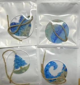 Detailed view of four acrylic sea glass suncatchers with shells and starfish ornaments