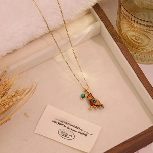 Golden titanium steel necklace with colorful enamel bird pendant and green bead in a gift box