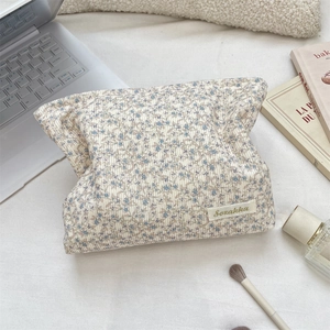Macro view of corduroy floral makeup bag with blue flower pattern and Szakka label