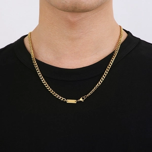 Detailed close-up of a golden Cuban link chain featuring a lobster clasp and rectangle plate