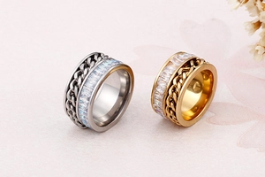 Close-up of gold and silver chain link spinner rings with zircon stones inlay