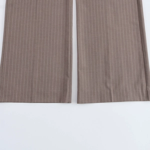 Detail view of brown vertical pinstripe trousers featuring a professional wide-leg cut