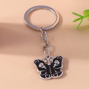 Gothic butterfly keychain with skull pattern on wings in black drip oil finish