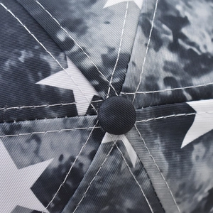 Macro shot of baseball cap top featuring star pattern, camouflage print and white stitching