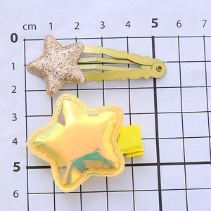 Sparkly glitter and iridescent star hair clips for girls shown with a centimeter size ruler