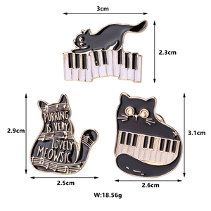 Detailed view of three cat piano enamel pins with exact measurements and weight