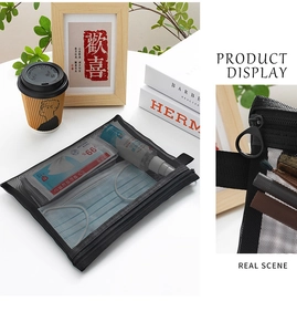 Detail of a black mesh zipper pouch used for organizing face masks and small spray bottles