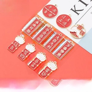 Detailed view of red and white Chinese enamel charms with lucky patterns for DIY jewelry
