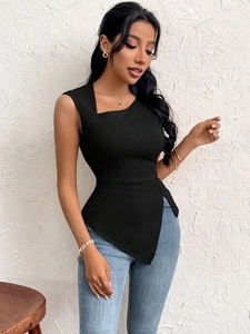 Detail of black one-shoulder top with asymmetrical hem paired with denim jeans