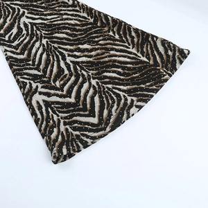Close-up of zebra print fabric with silver rhinestone embellishments on flared pants