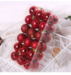 Detail showing 36 red Christmas balls in various finishes inside a transparent box